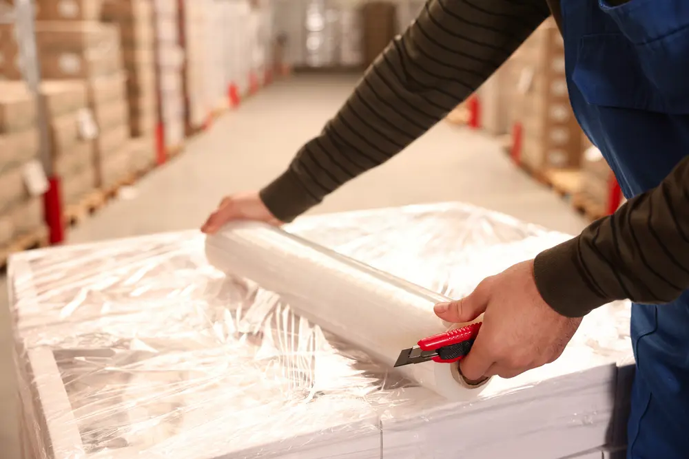 a person holding a roll of plastic
