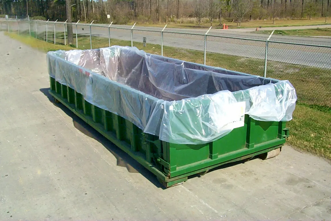 a green dumpster with plastic covering