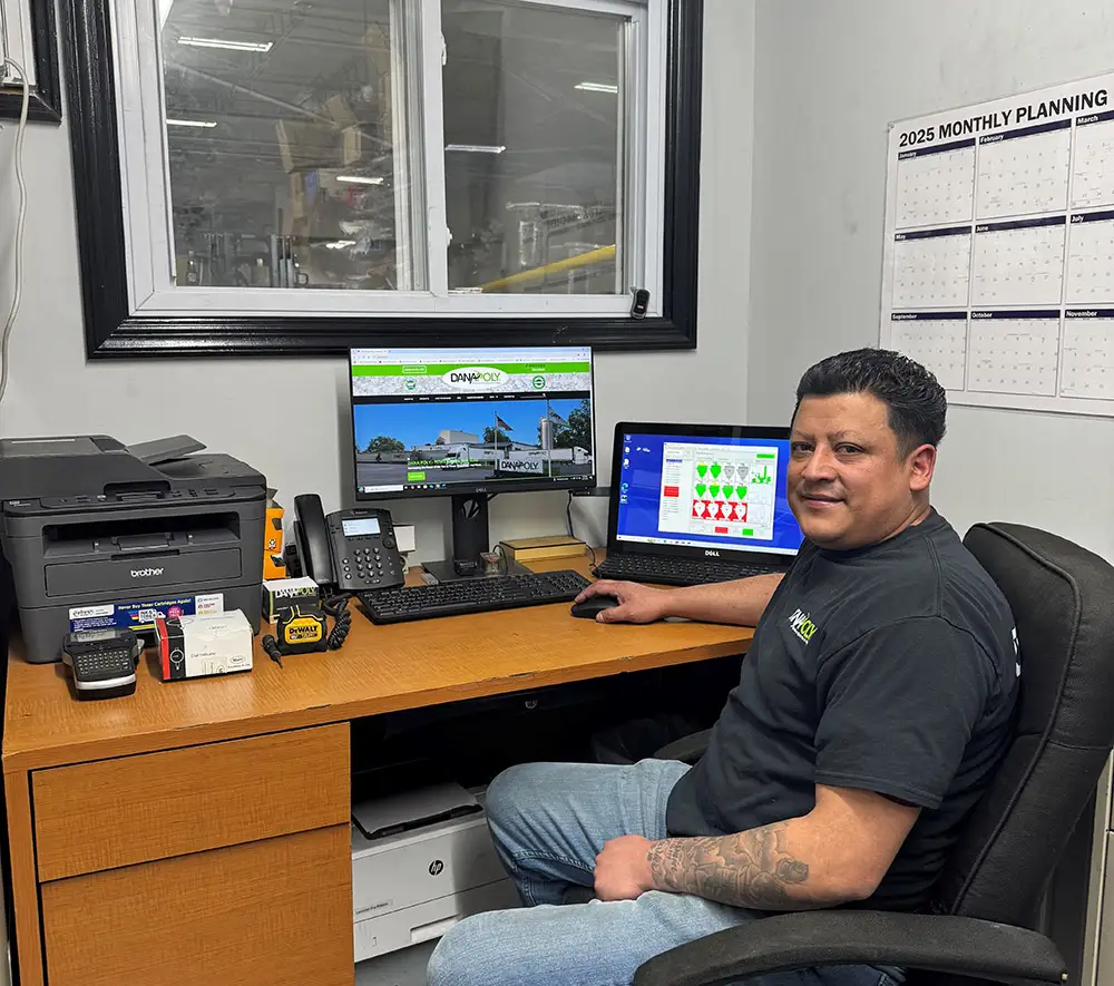 a man sitting at a desk with computer screens
