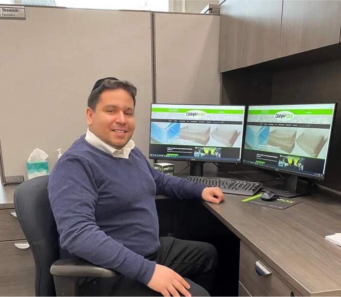 a man sitting at a desk with multiple computer screens