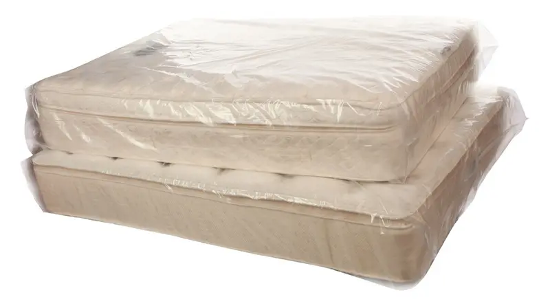 a stack of mattresses wrapped in plastic